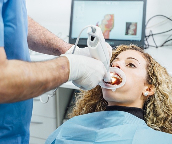 Dentist scanning patient's smile to capture digital impressions