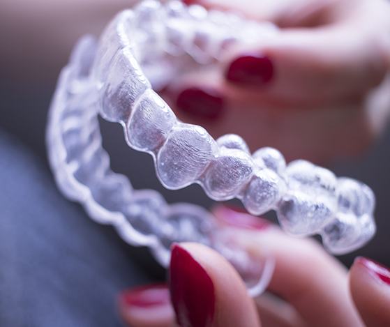 Hand holding a Nu Smile Aligner tray