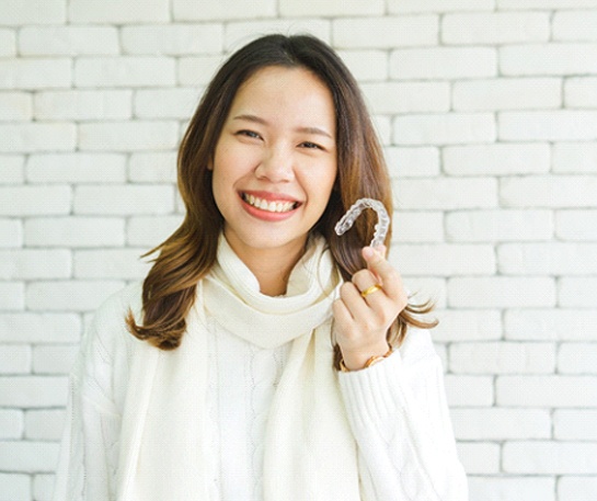 Woman holding Nu Smile Aligners for Adults in New Jersey