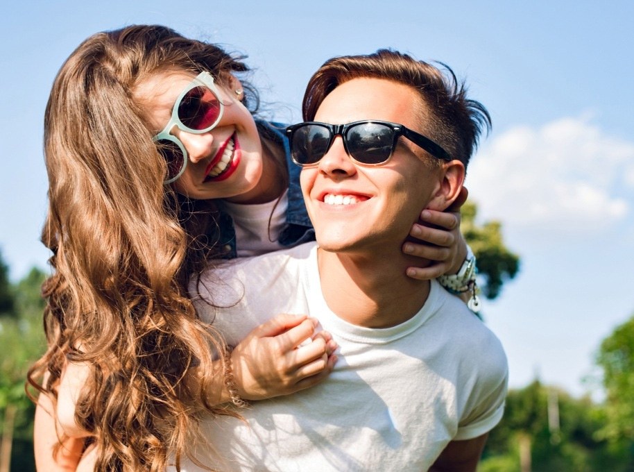 Young man and woman with aligned smiles after Nu Smile Aligner treatment