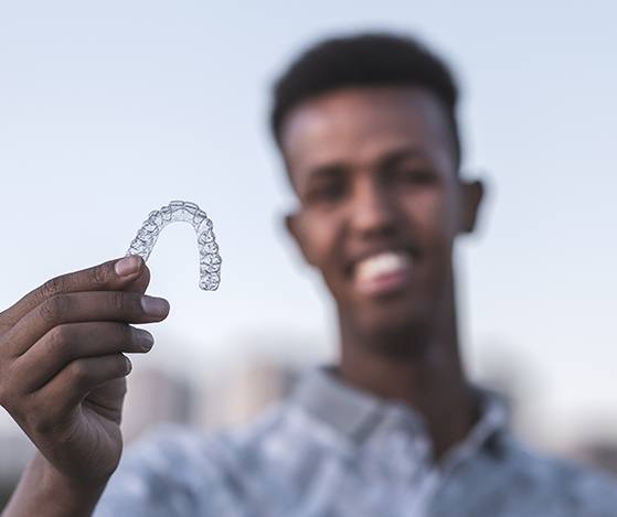 Young man holding Nu Smile Aligner tray