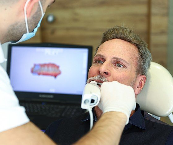Dentist using digital tool to scan patient's smile