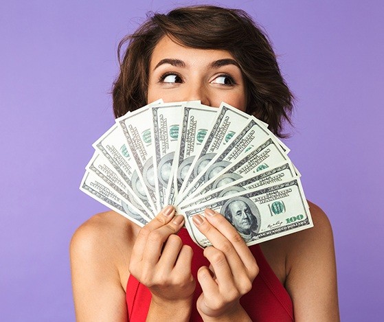 Woman fanning out hundred dollar bills