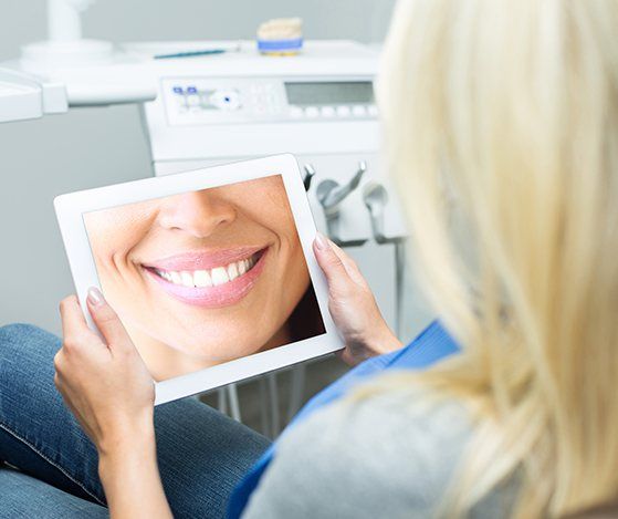 Woman looking at smile design on tablet computer during Nu Smile Aligner treatment process