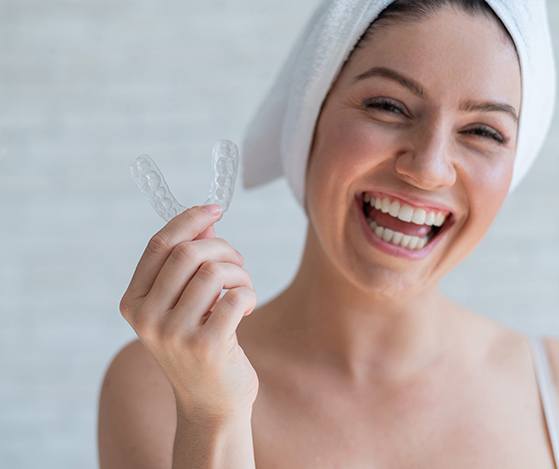 Woman holding a Nu Smile Aligner tray