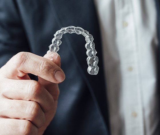 Hand holding a D I Y clear braces tray