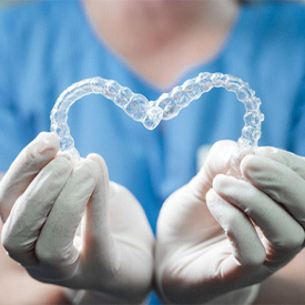 Eatontown dentist holding Invisalign retainers in Eatontown