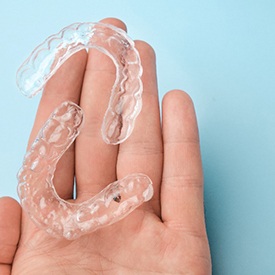 Closeup of patient holding Invisalign clear aligners