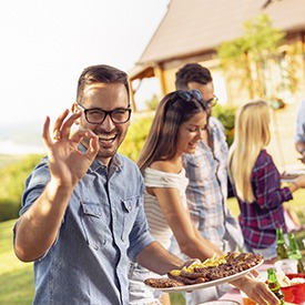 Man with Invisalign in Brick giving A-Ok sign at a BBQ