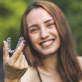 Woman holding clear aligner