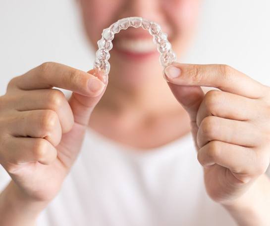 Woman outside holding Invisalign in Eatontown 