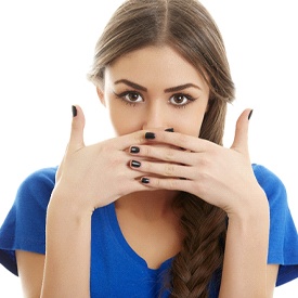 Woman covering her mouth, embarrassed by her underbite