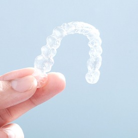 Close-up of hand holding a new smile clear aligner