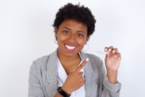 Confident woman holding one of her Nu Smile Aligners