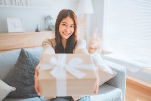 Smiling woman holding simple gift box